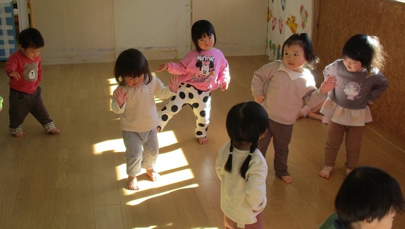 1歳児が音楽に合わせて体を動かしている。