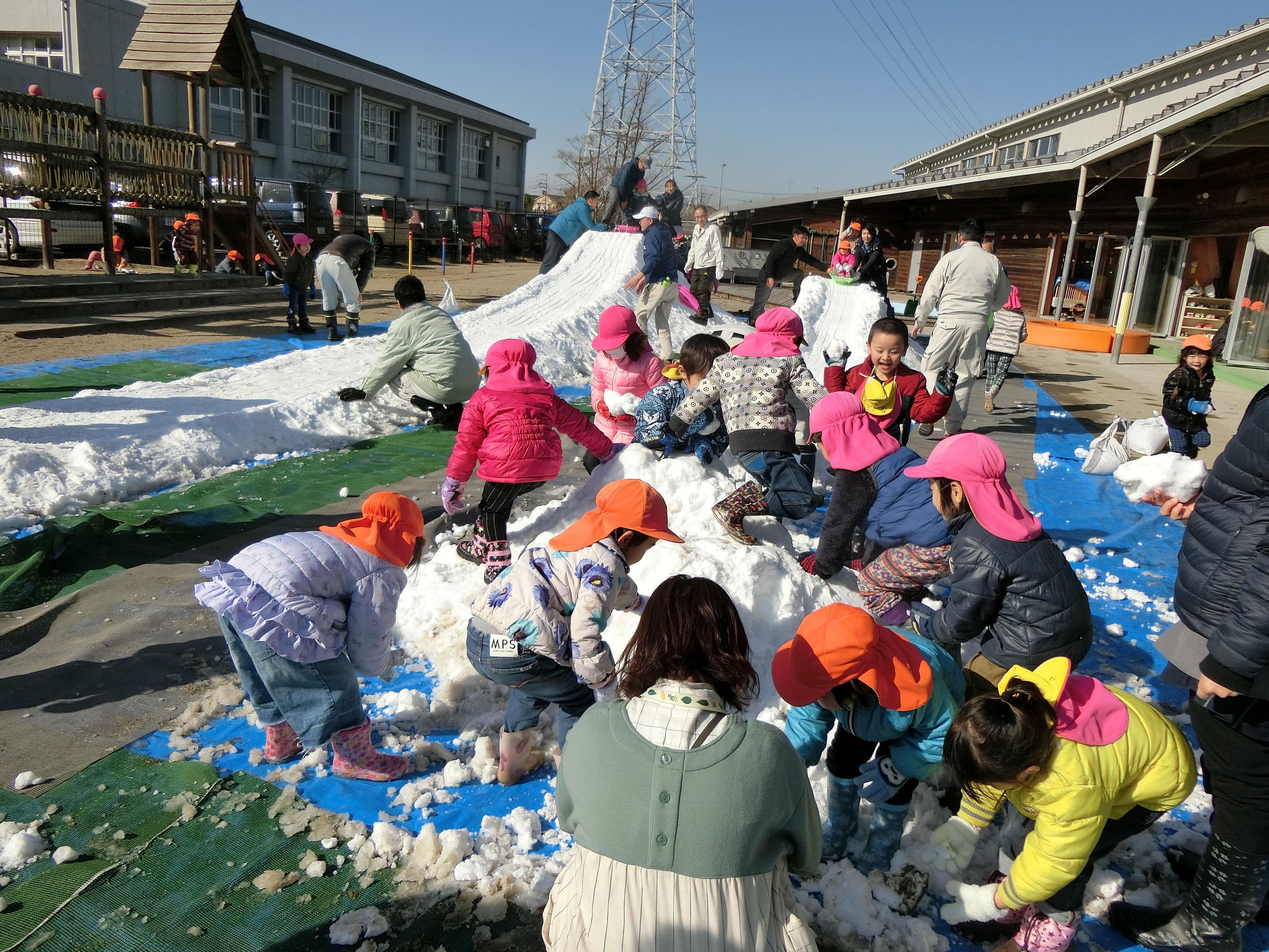 子どもたちが雪の山で遊んでいる写真