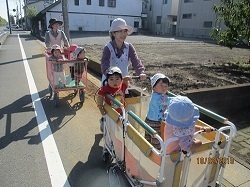 天気の良いお散歩日和。0歳児が帽子を被り、カートに乗って散歩へ出かけます。