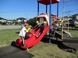 5歳児の散歩先はきんもくせい公園。滑り台で滑ったり、階段の柵にぶら下がったりして遊んでいます。