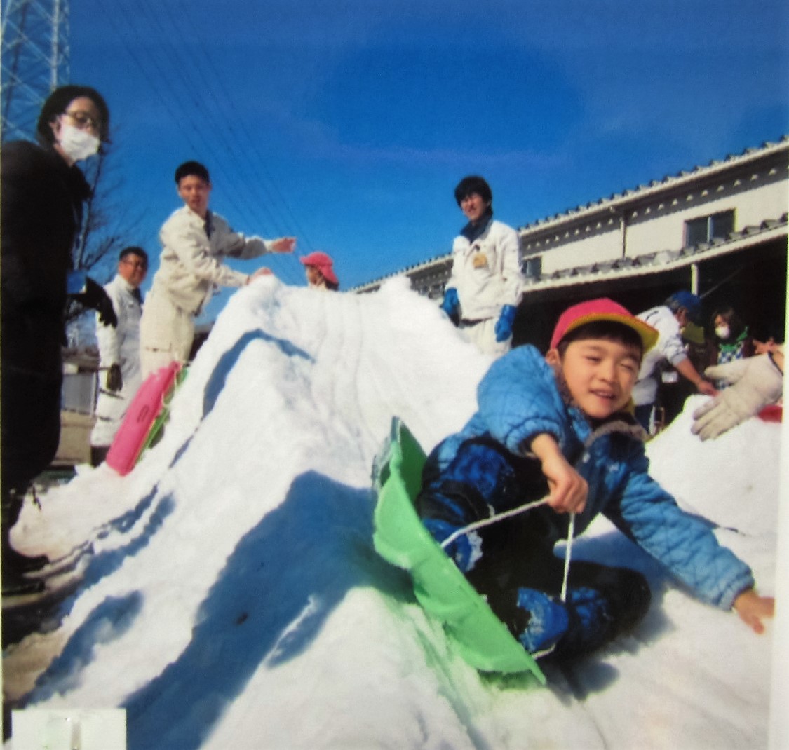 ソリで滑る子ども