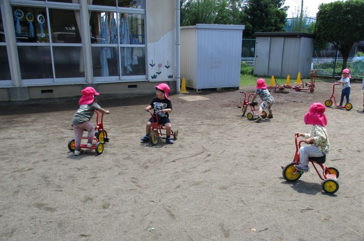 子どもたちは三輪車やキックボードで遊んでいる。
