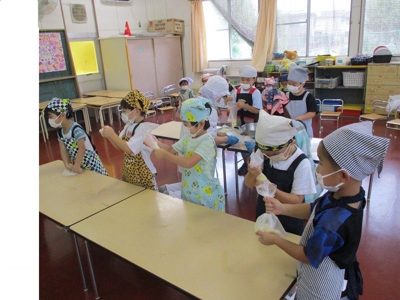 蒸かしたじゃがいもと片栗粉、塩をポリ袋へ入れ、子どもたちが捏ねている。