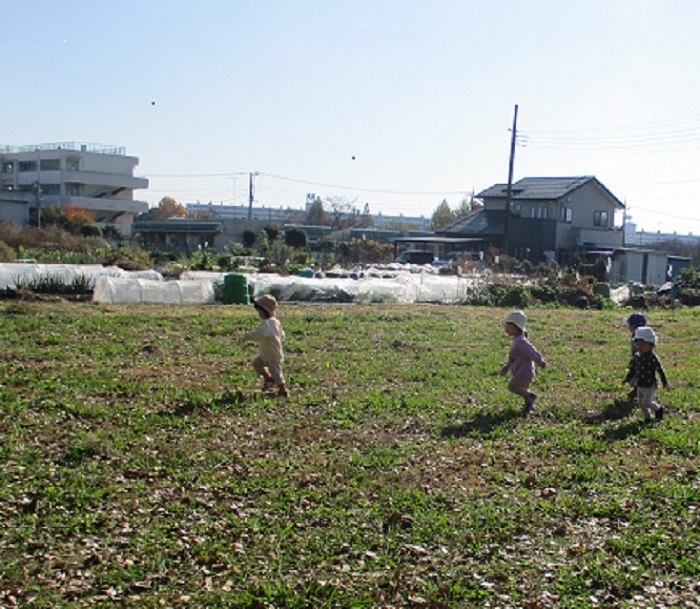 子どもたちが原っぱを走っている。
