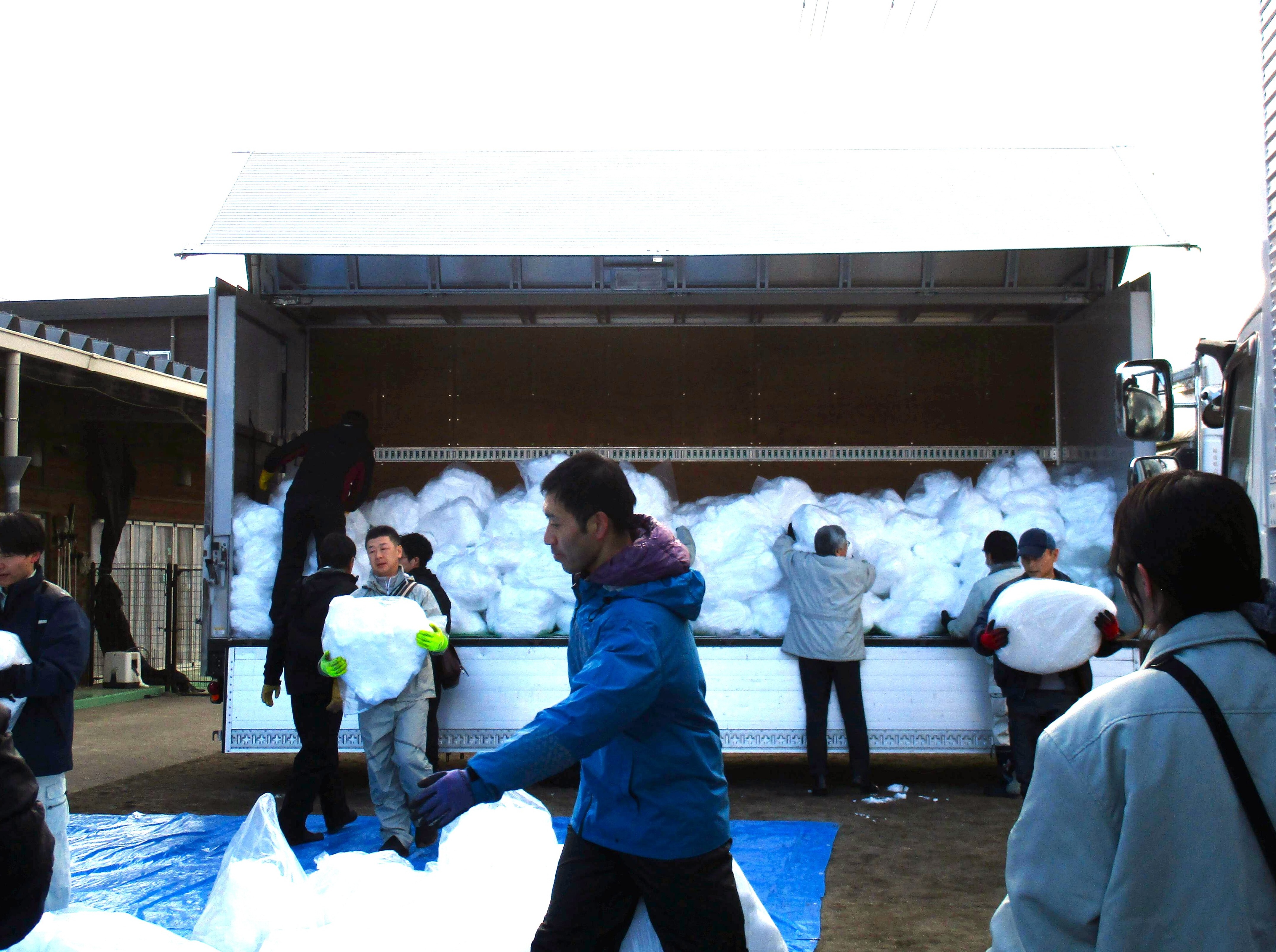 たくさん積み込まれた雪をトラックから降ろしている