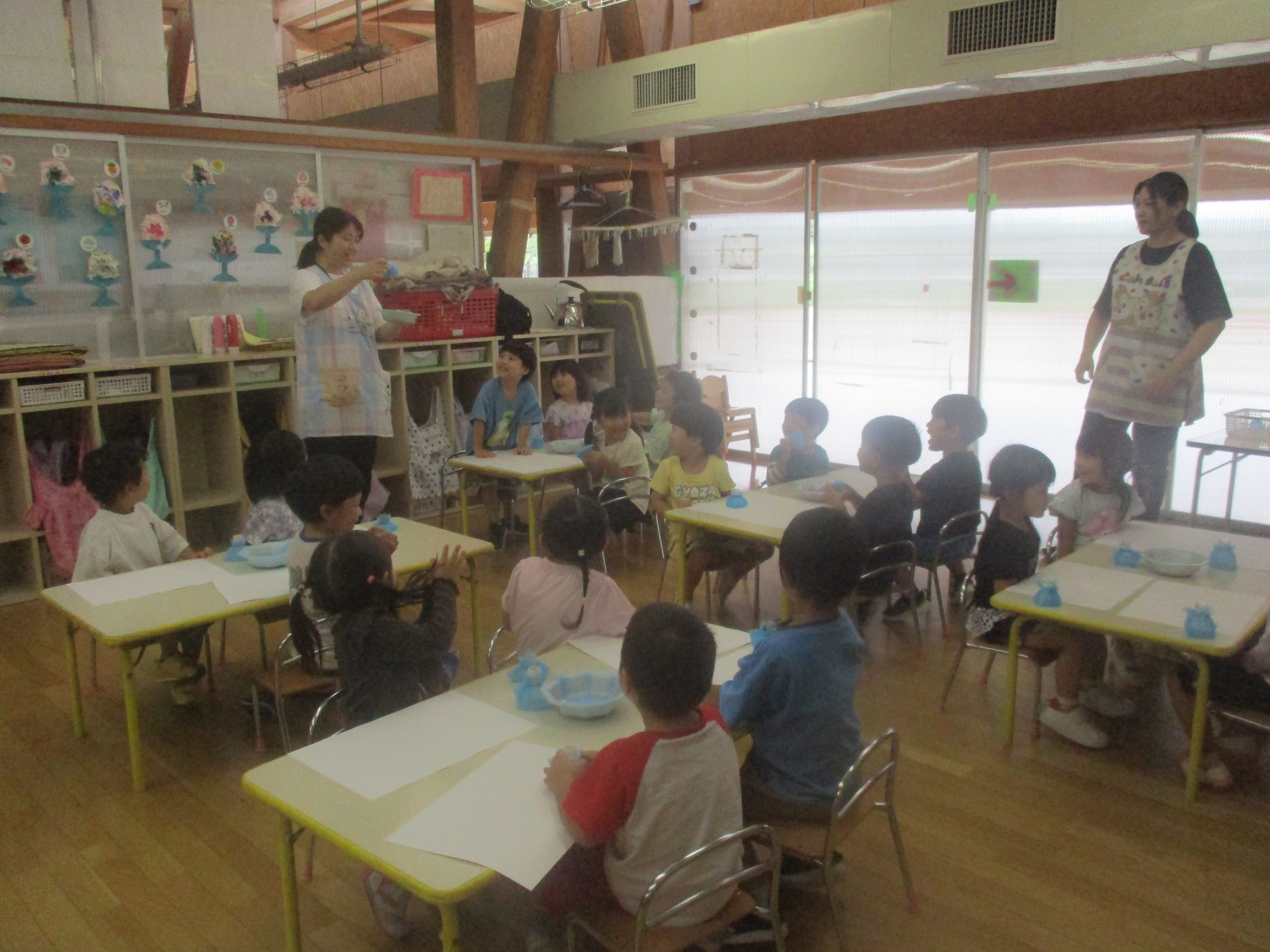 子どもたちが集まって保育士の説明を聞いている。
